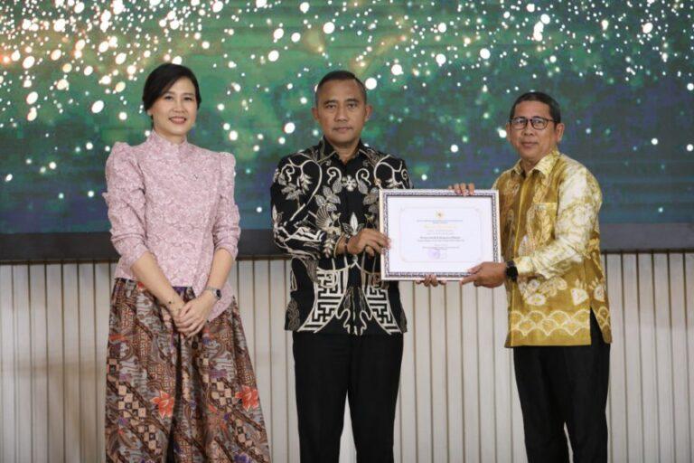 Mewakili Bupati, Pj Sekda Kabupaten Banjar, Ikhwansyah, penghargaan Kabupaten/Kota Layak Anak (KLA) tahun 2025 kategori Nindya, Jumat (8/8/2025). Foto: RSB